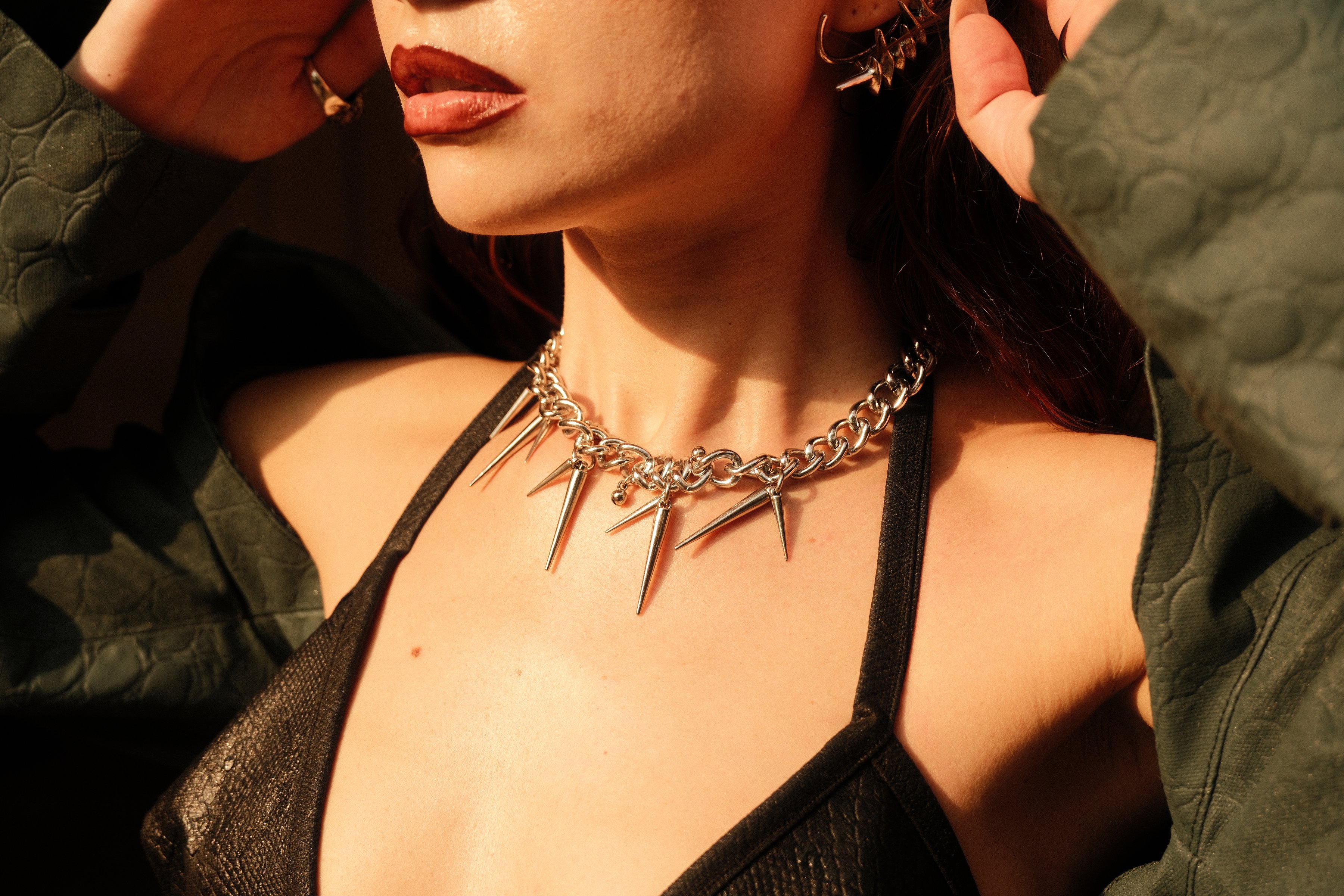 Close crop of red lips and a spiked necklace
