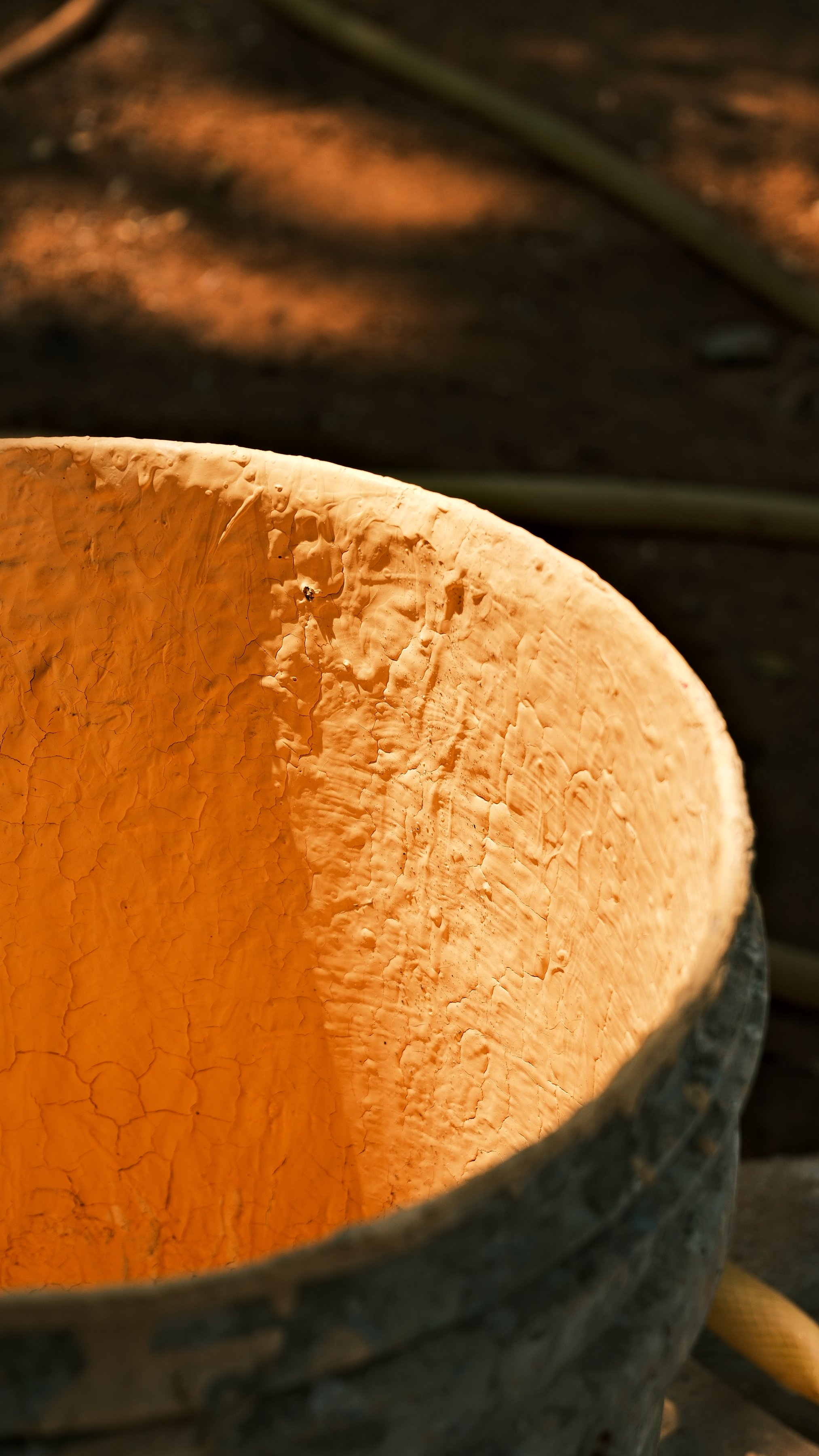 A rough coconut-shell bowl glowing orange in the sun