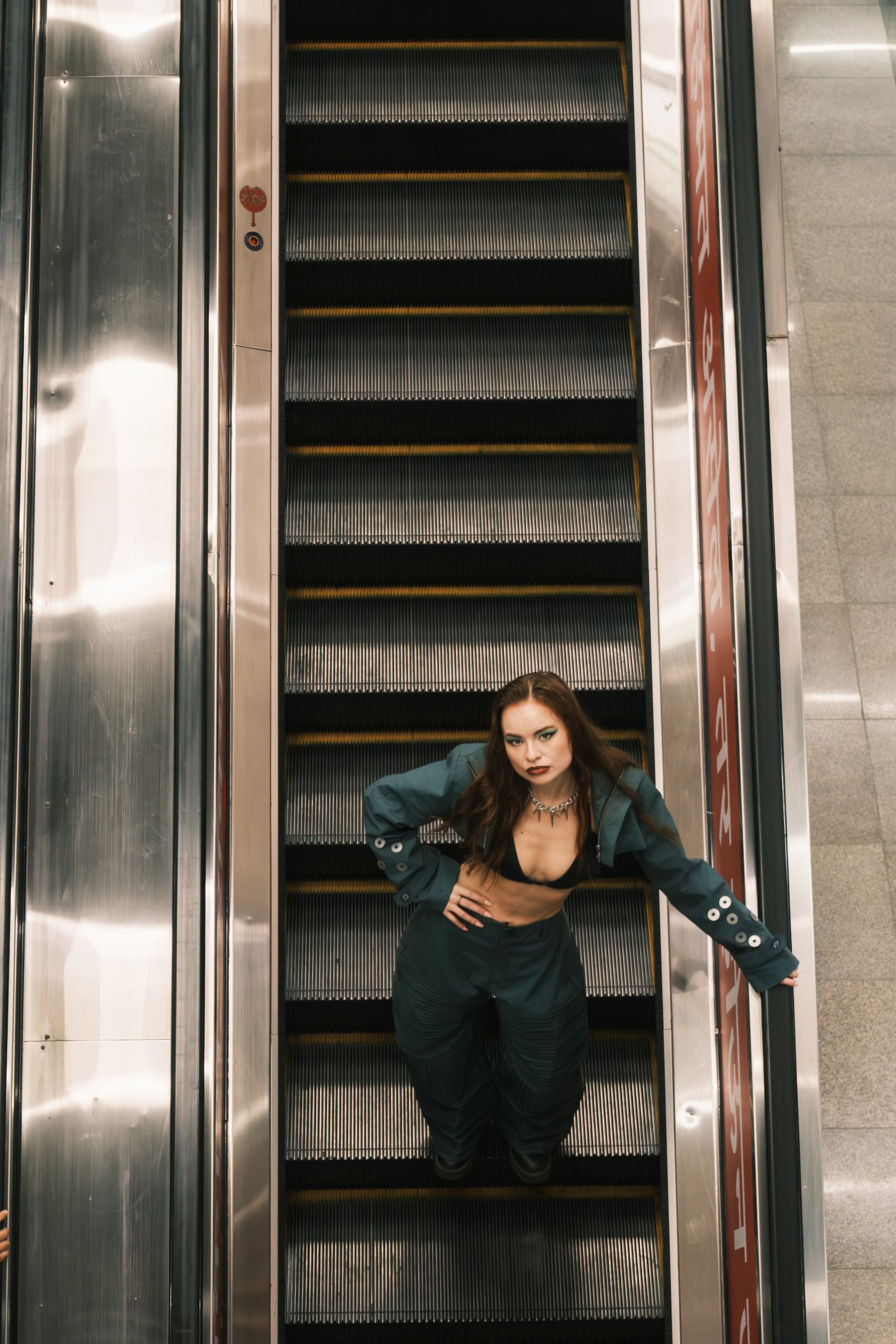 A model with one hand on the rail and one on the hip, framed from above