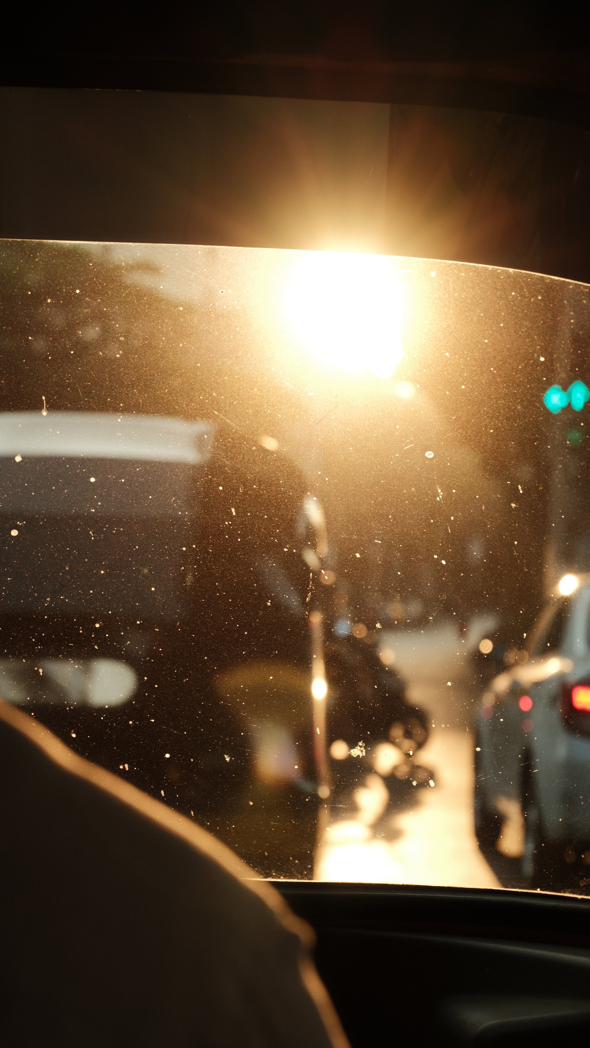 Low sun flaring through a taxi windshield in evening traffic