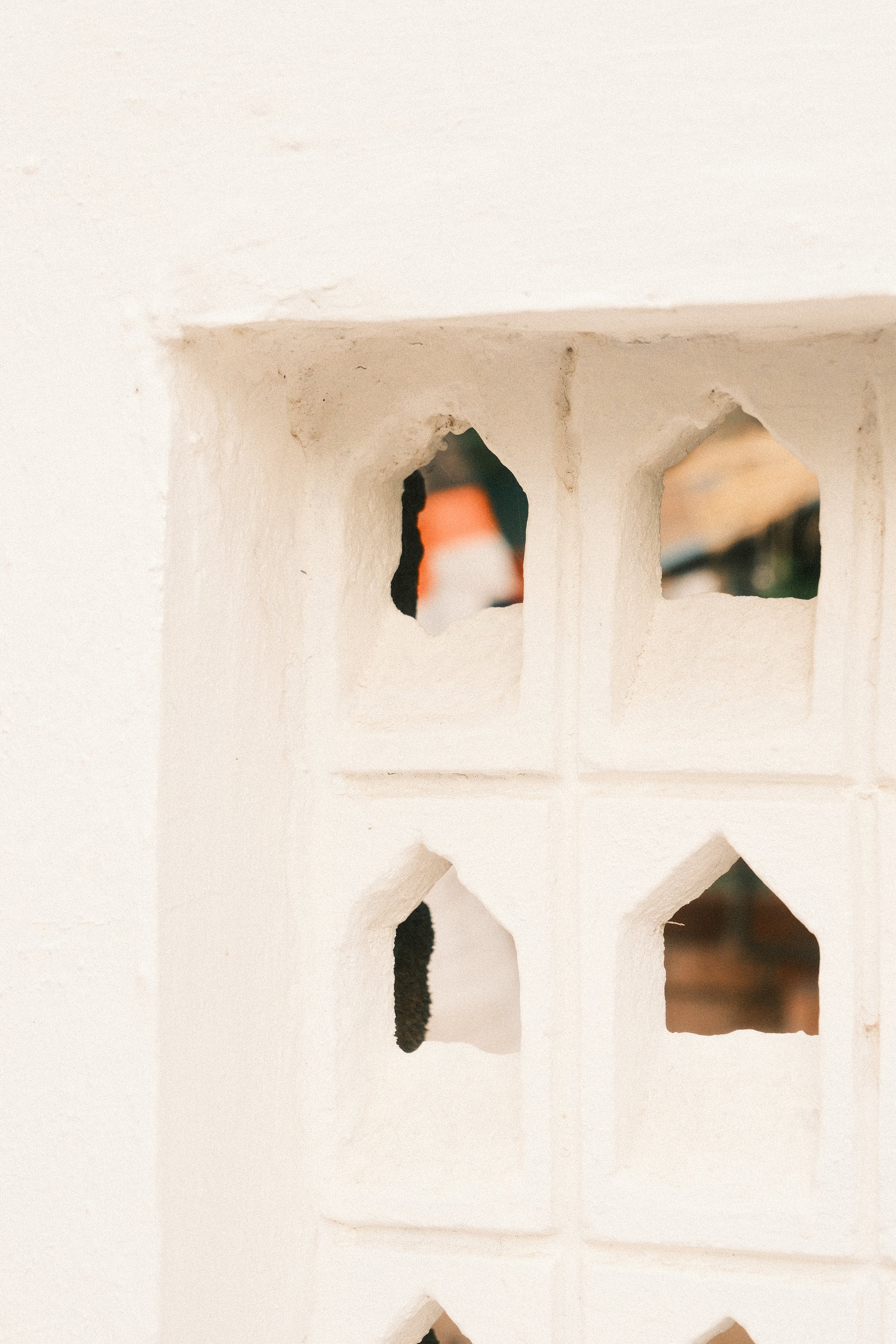 A white wall with small arched cut-outs