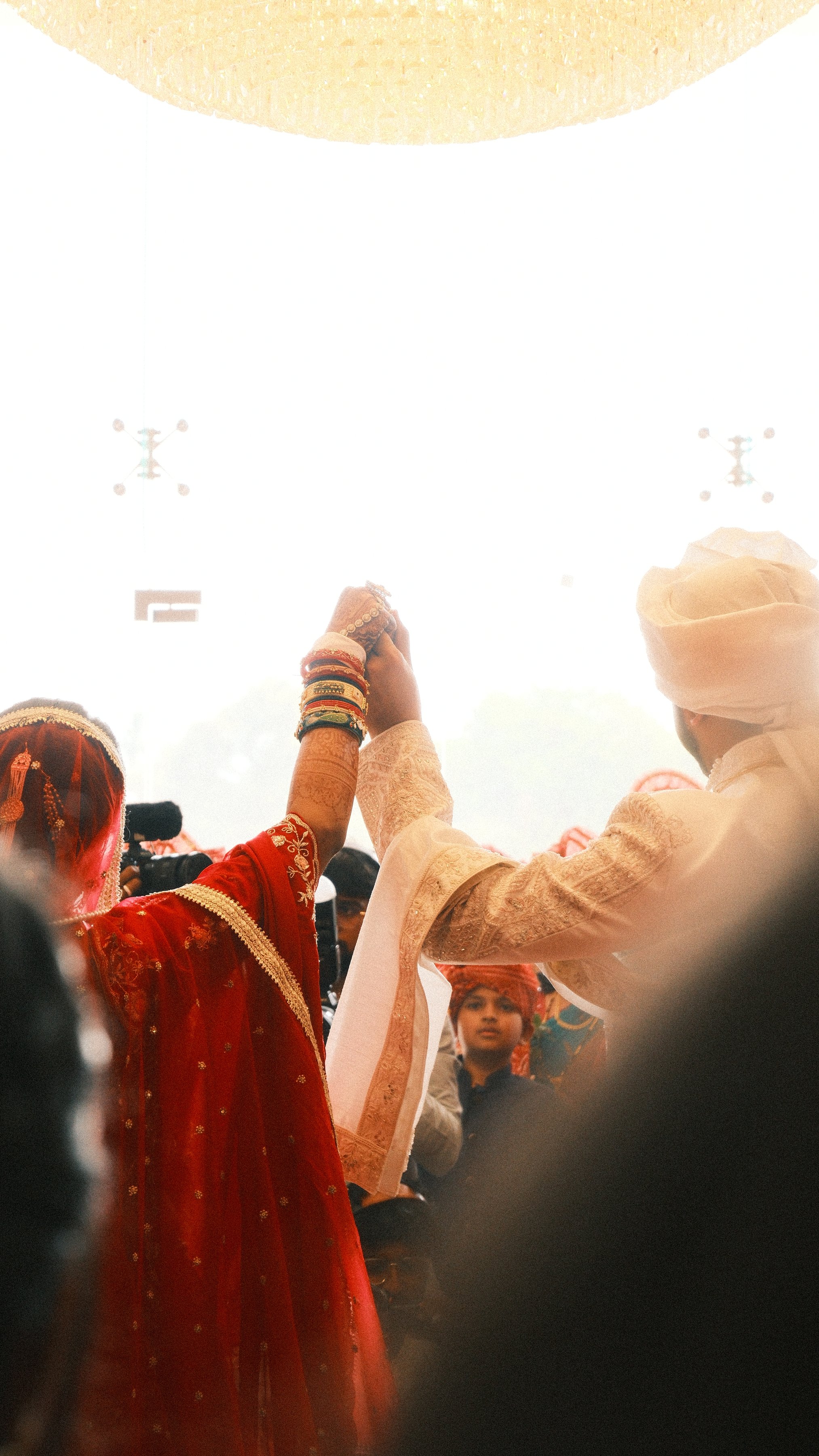 The couple raising joined hands under a bright canopy