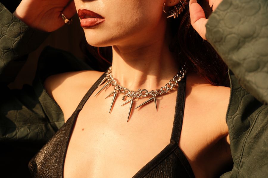 Close crop of red lips and a spiked necklace