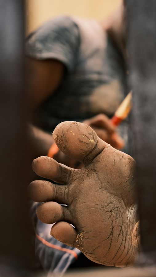 An artisan painting the clay foot of an idol