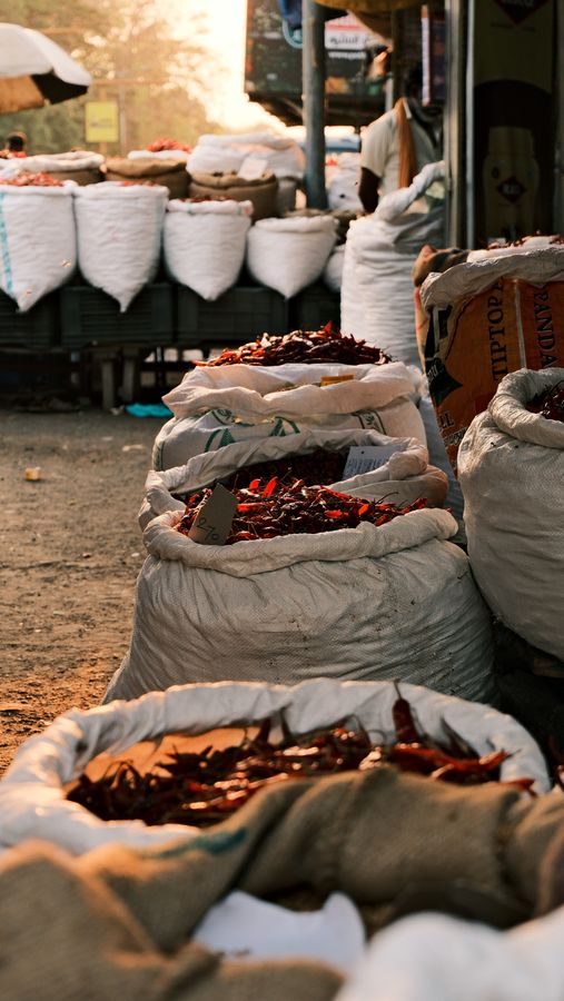 Open sacks of dried red chillies at a market stall