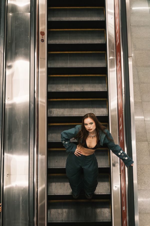 A model with one hand on the rail and one on the hip, framed from above