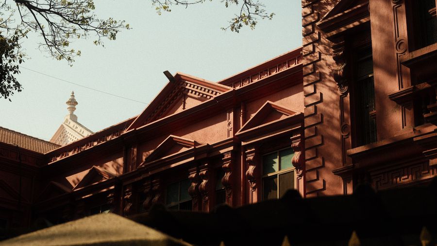 The steep gables of a red brick heritage building against the sky