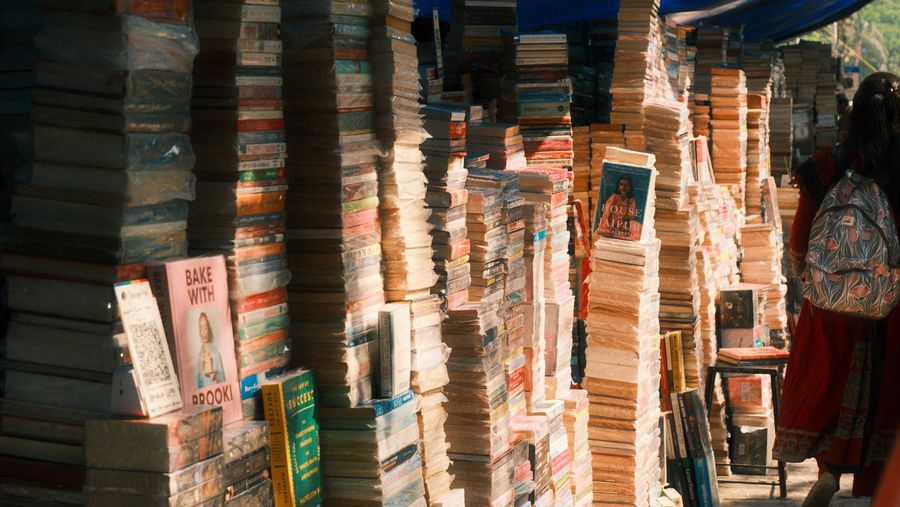 Stacks of secondhand books piled high at a street stall