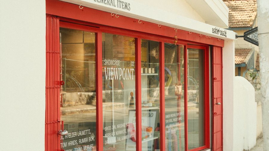 The red-framed shopfront and its window displays on a quiet street