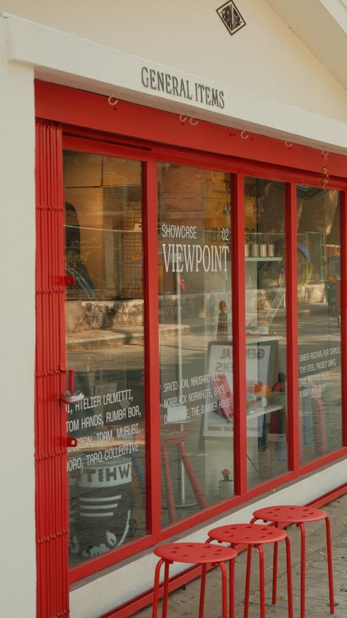 Red stools beneath the shop window and its painted lettering