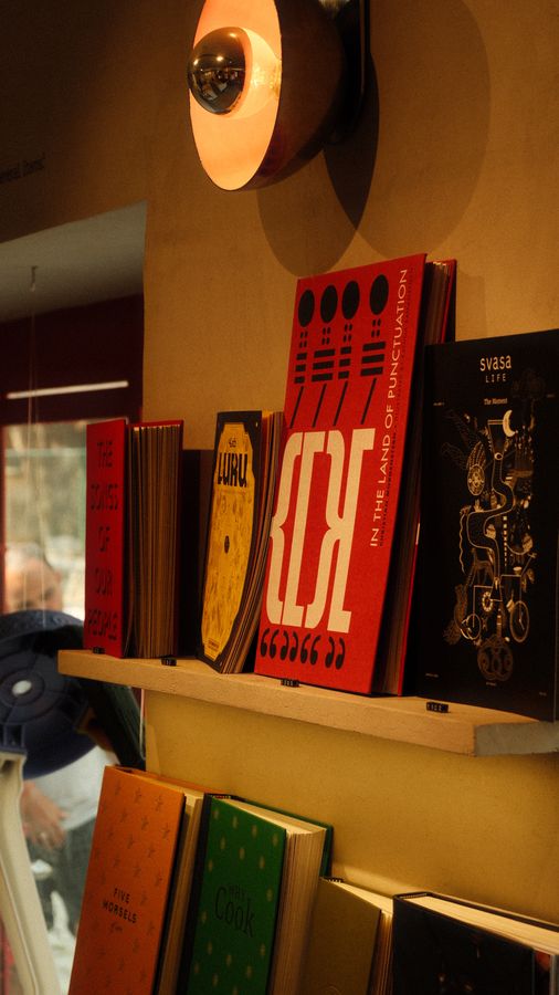 Books with bright covers on a warm-lit bookshop shelf
