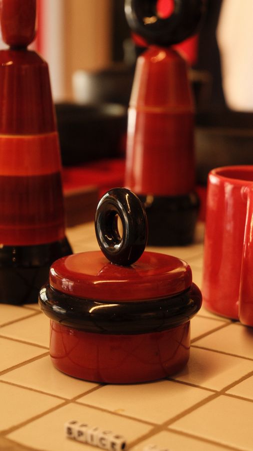 Red and black lacquered wooden toys on a tiled counter