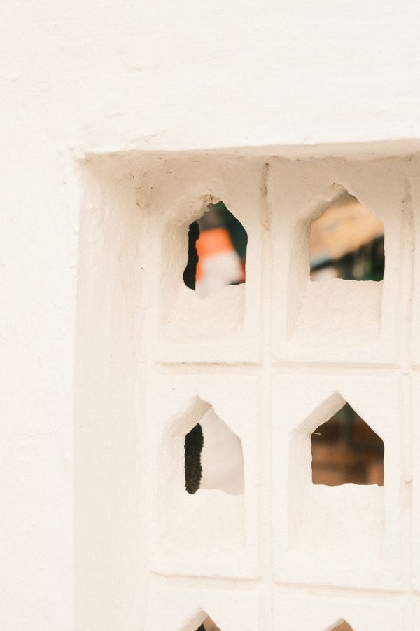 A white wall with small arched cut-outs