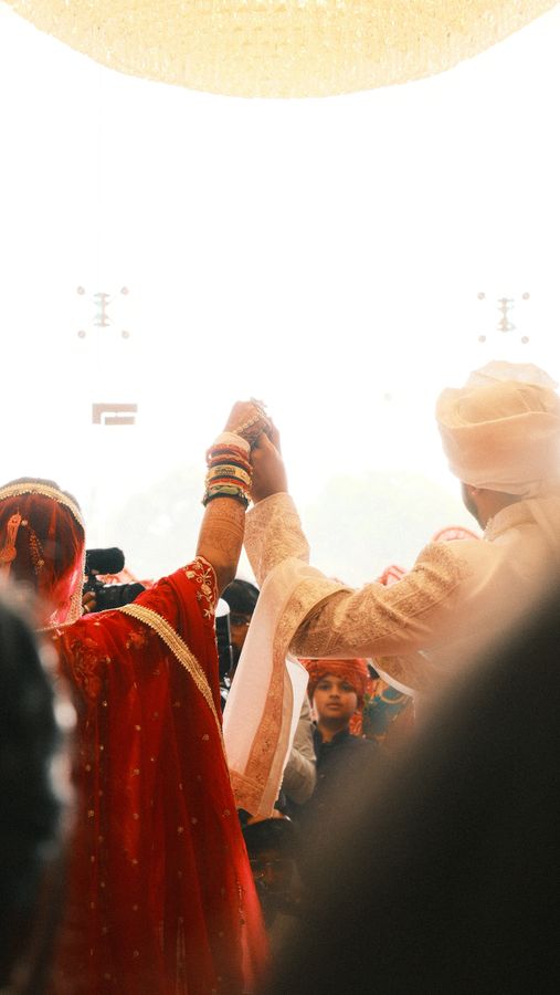 The couple raising joined hands under a bright canopy
